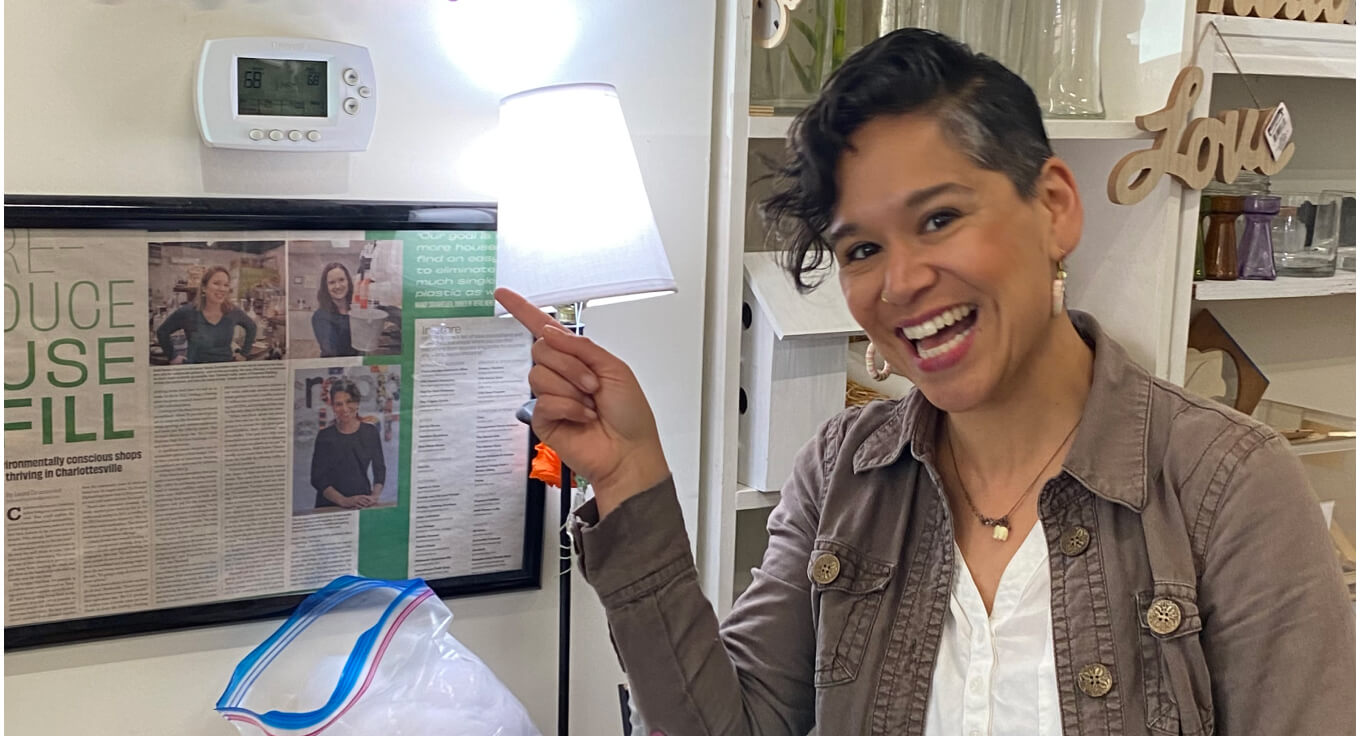 Woman smiling and pointing at her programmed thermostat